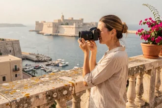 Photographe amateur tenant un appareil photo au belvédère des jardins Barrakka supérieurs à Malte avec vue sur le Grand Port